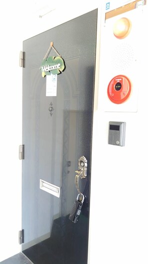 A door with a 'Welcome' sign, a key holder, a red emergency alarm, and a keypad lock. - Hokusei Building 6F (Sapporo)