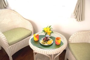 Relax in this serene space with a comfortable seating area featuring two wicker chairs and a round table.