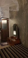 A room with a wooden vanity, a mirror, a door, and a striped rug.