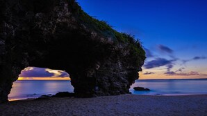 Un paysage côtier avec une formation rocheuse naturelle et une vue dégagée sur la mer.