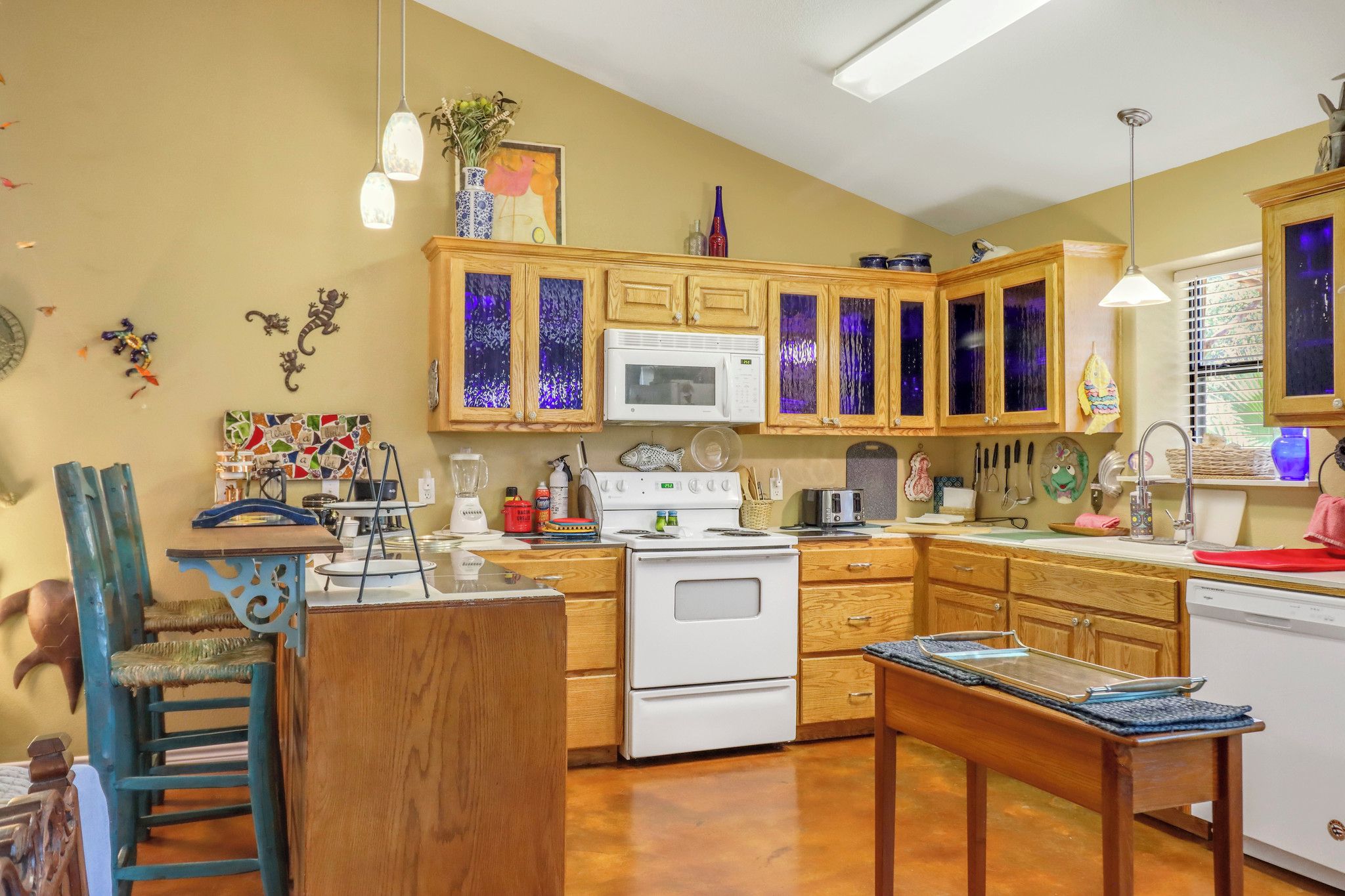 A kitchen with wooden cabinets, a white stove, a microwave, and various kitchen appliances.