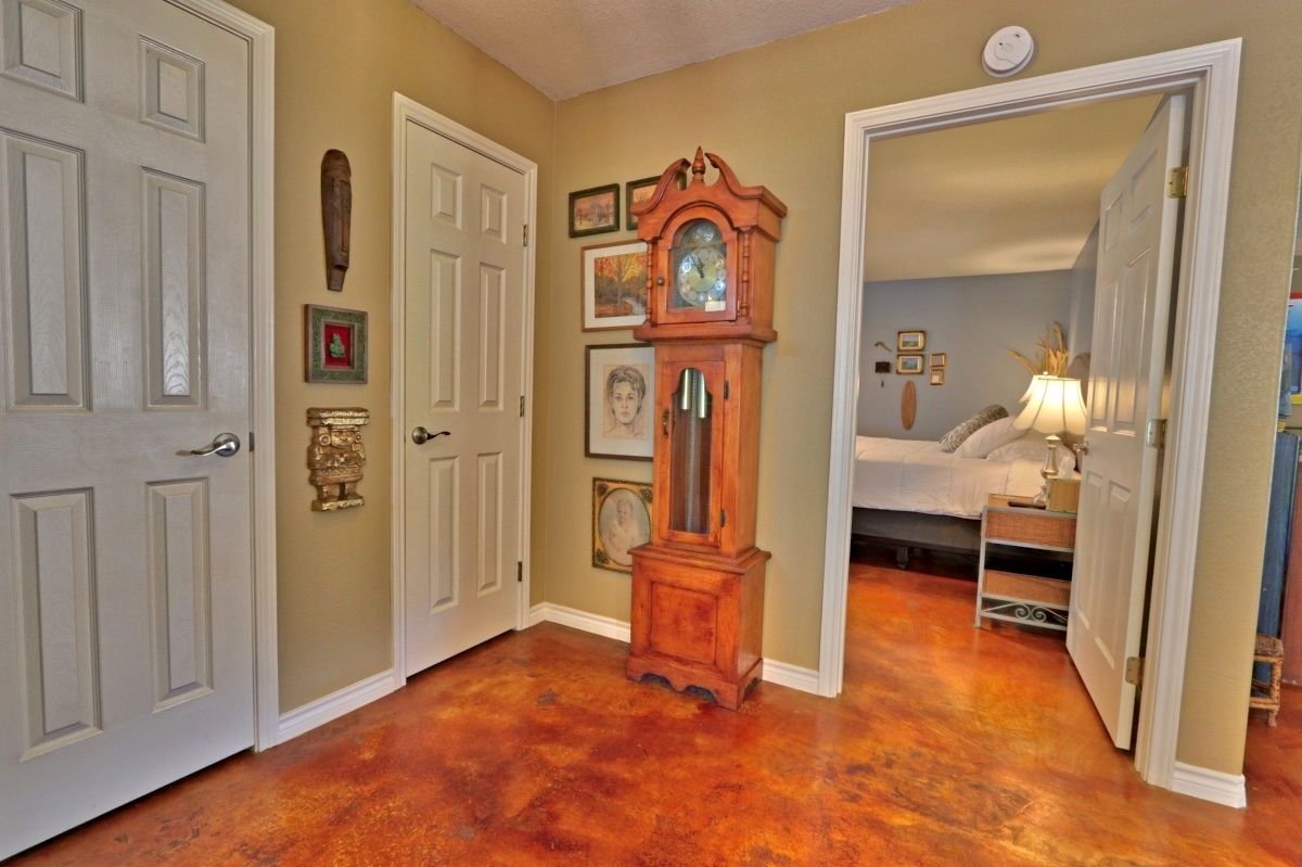 A hallway with a wooden floor, white doors, and a grandfather clock.