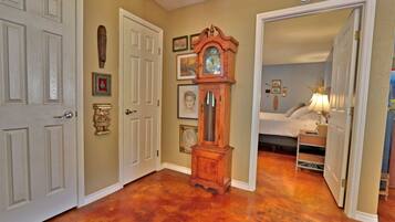 A hallway with a wooden floor, white doors, and a grandfather clock.
