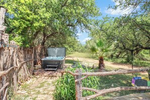 Un espace extérieur clos, équipé d’un barbecue, d’un hamac et d’une petite piscine.
