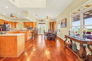 Una cocina amplia con gabinetes de madera, una isla grande y un comedor con mesa y sillas.