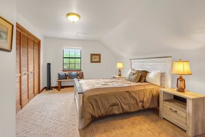 A bedroom with a bed, bedside tables, a window, and a closet. - 3 bedroom pet friendly log cabin with private hot tub! (Wimberley)