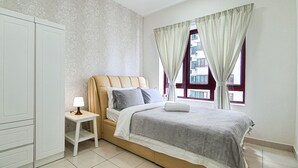 Een slaapkamer met een bed, nachtkastje, lamp en een raam met gordijnen.