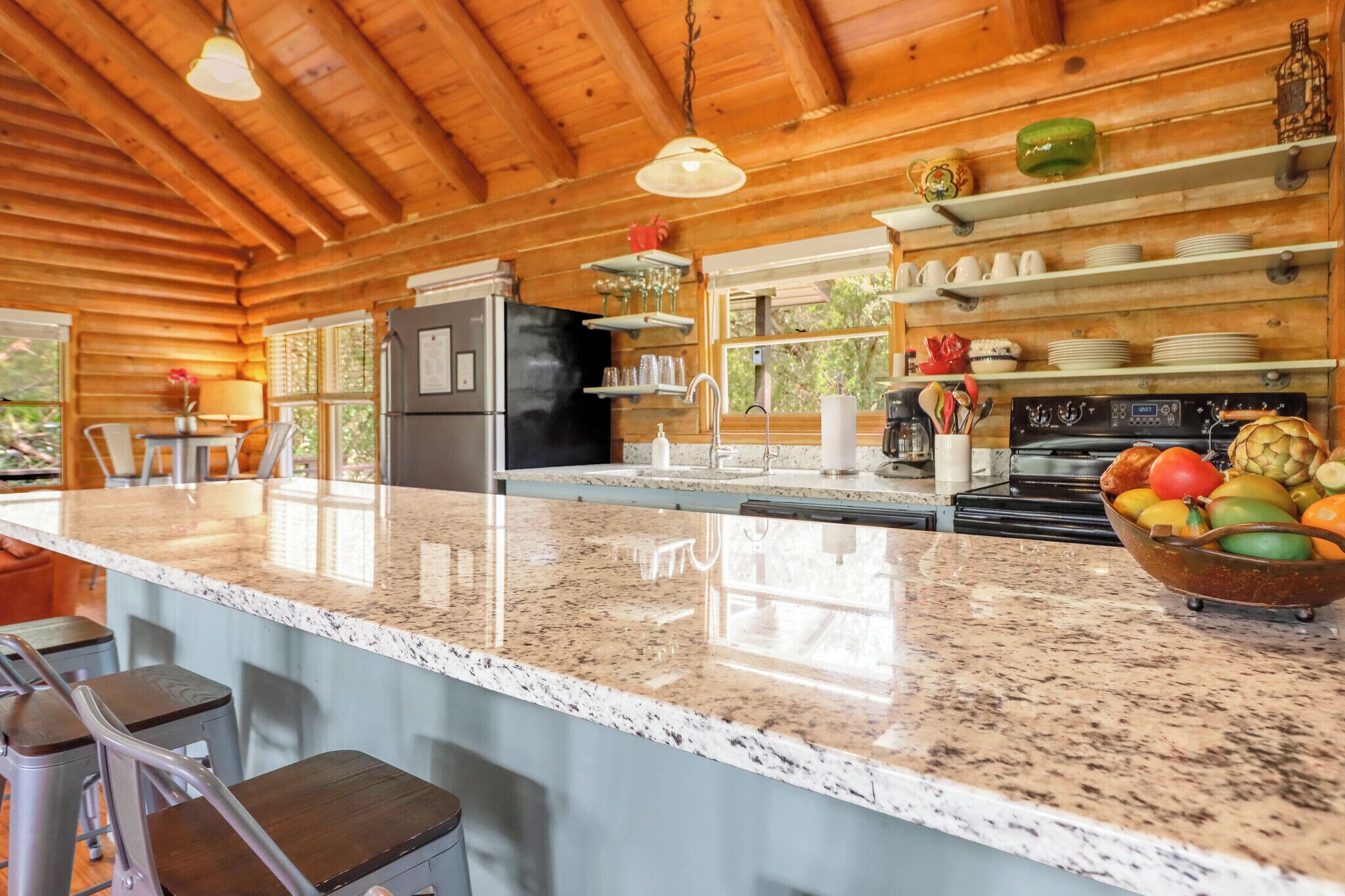 Cocina con encimeras de granito, electrodomésticos de acero inoxidable y armarios de madera.