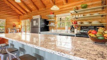 Cocina con encimeras de granito, electrodomésticos de acero inoxidable y armarios de madera.