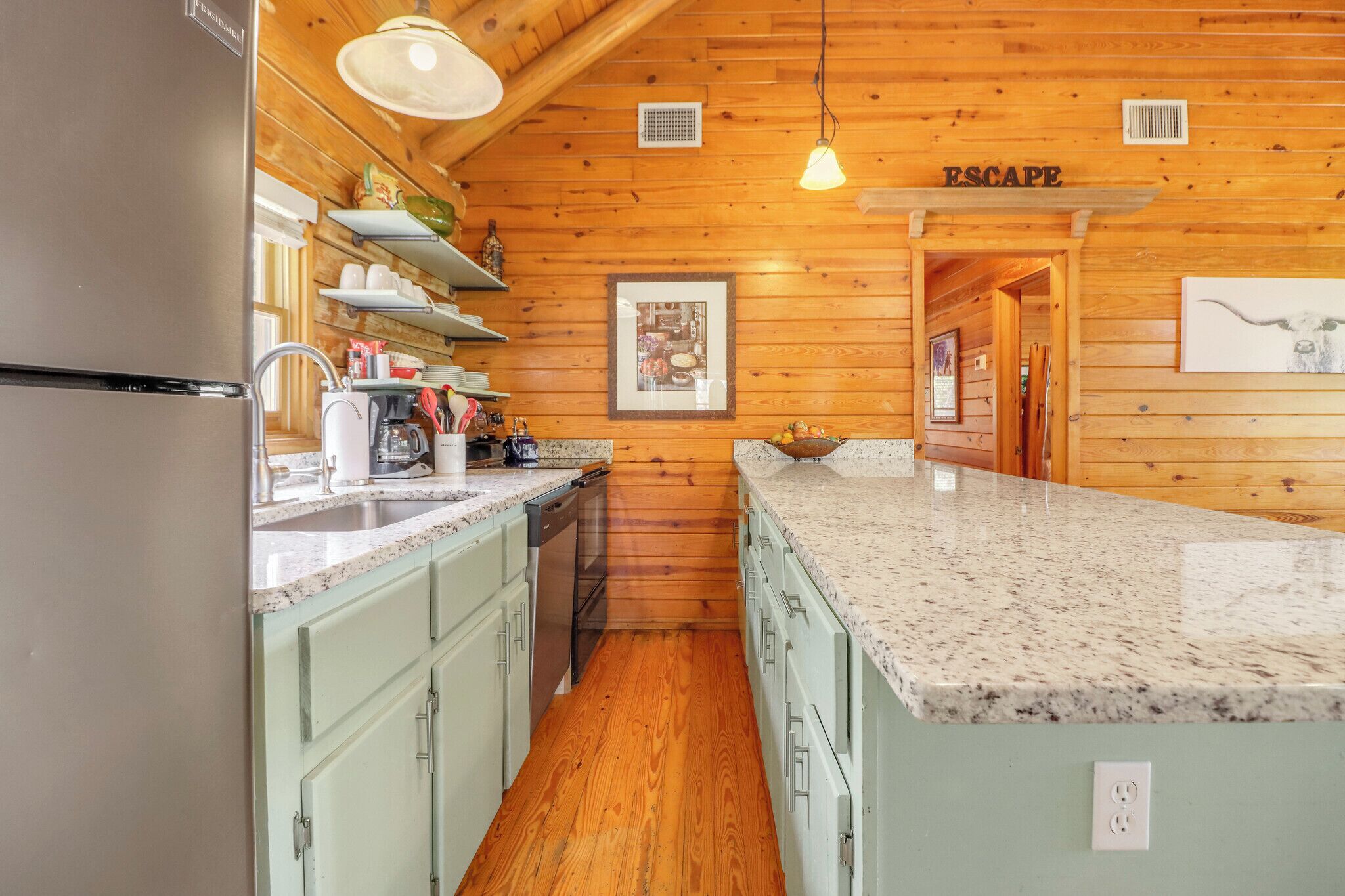 Eine Küche mit Holzwänden, einer Arbeitsplatte aus Granit und einem Kühlschrank.