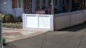 A covered outdoor seating area with a white fence and a table with chairs. - Private House for Rent in Mauritius at a very competitive Price and very secure. (Phoenix)