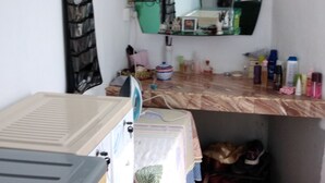 A small, cluttered room with a bed, a mirror, and various personal items on the counter. - Private House for Rent in Mauritius at a very competitive Price and very secure. (Phoenix)
