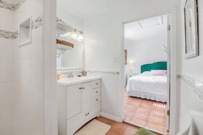Een hotelbadkamer met een witte wastafel, een spiegel en een gootsteen.