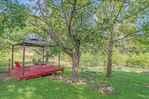 A gazebo with a table and chairs in a grassy area with trees. - Cozy and clean loft on the Blanco River - Minutes from downtown Wimberley! (Wimberley)