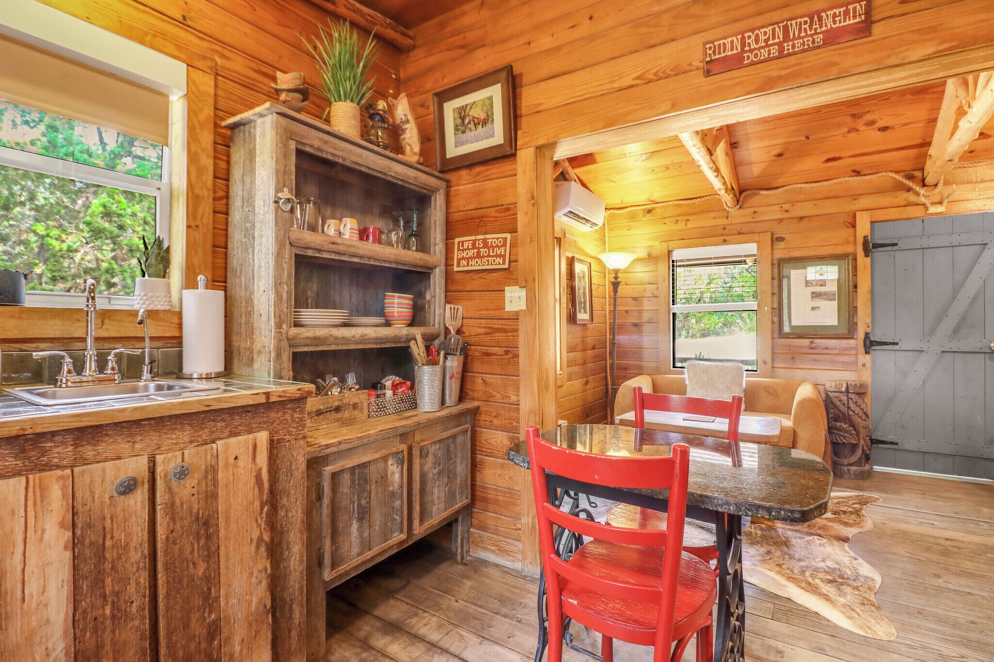 Un intérieur rustique en bois, comprenant un coin cuisine, une table à manger et des chaises.