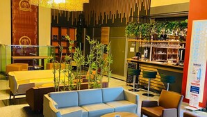 Eine moderne Lobby mit Sitzgelegenheit, einer Bar und einer Treppe.