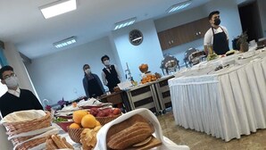 Ein reichhaltiges Buffet mit verschiedenen Speisen und einer Wanduhr.