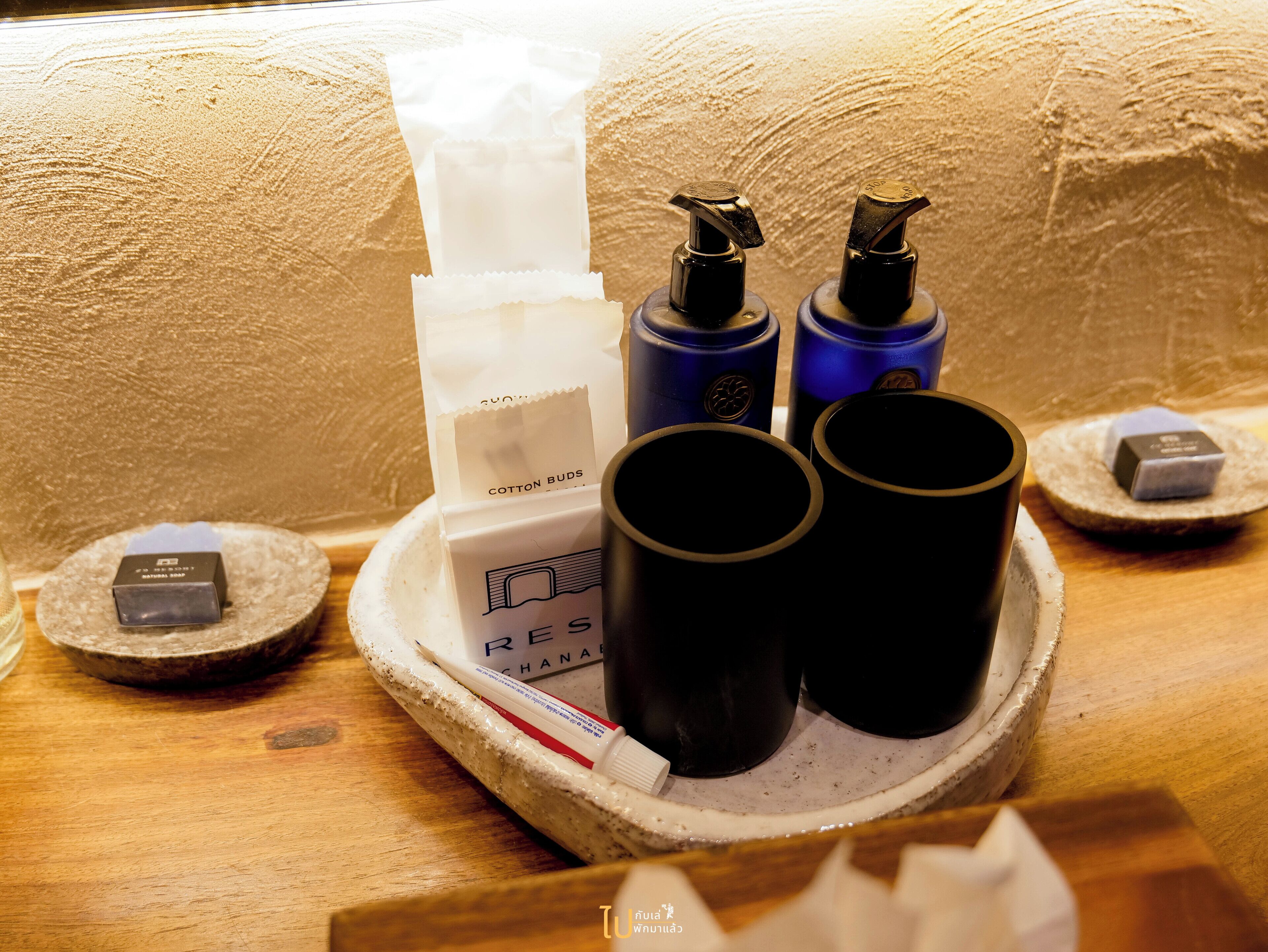 A tray with various toiletries including a bottle of lotion, a bottle of shampoo, and a tube of cream.