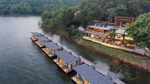 A riverside hotel with floating bungalows and a main building with outdoor seating. - Z9 Resort (Si Sawat)