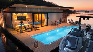 A modern villa with a swimming pool, outdoor seating, and a boat dock. - Z9 Resort (Si Sawat)