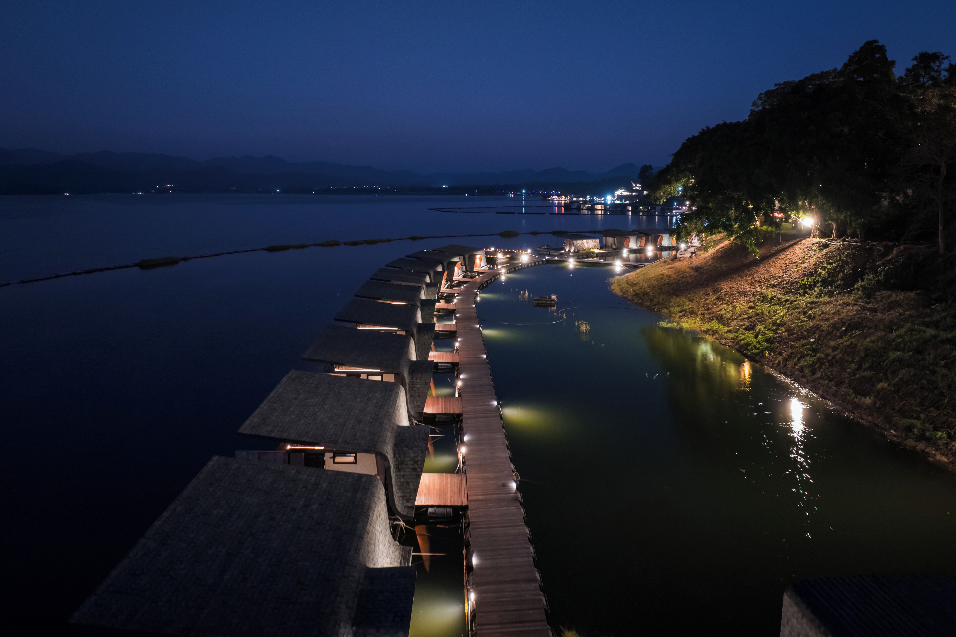A waterfront hotel with wooden walkways and rooms extending into the water.