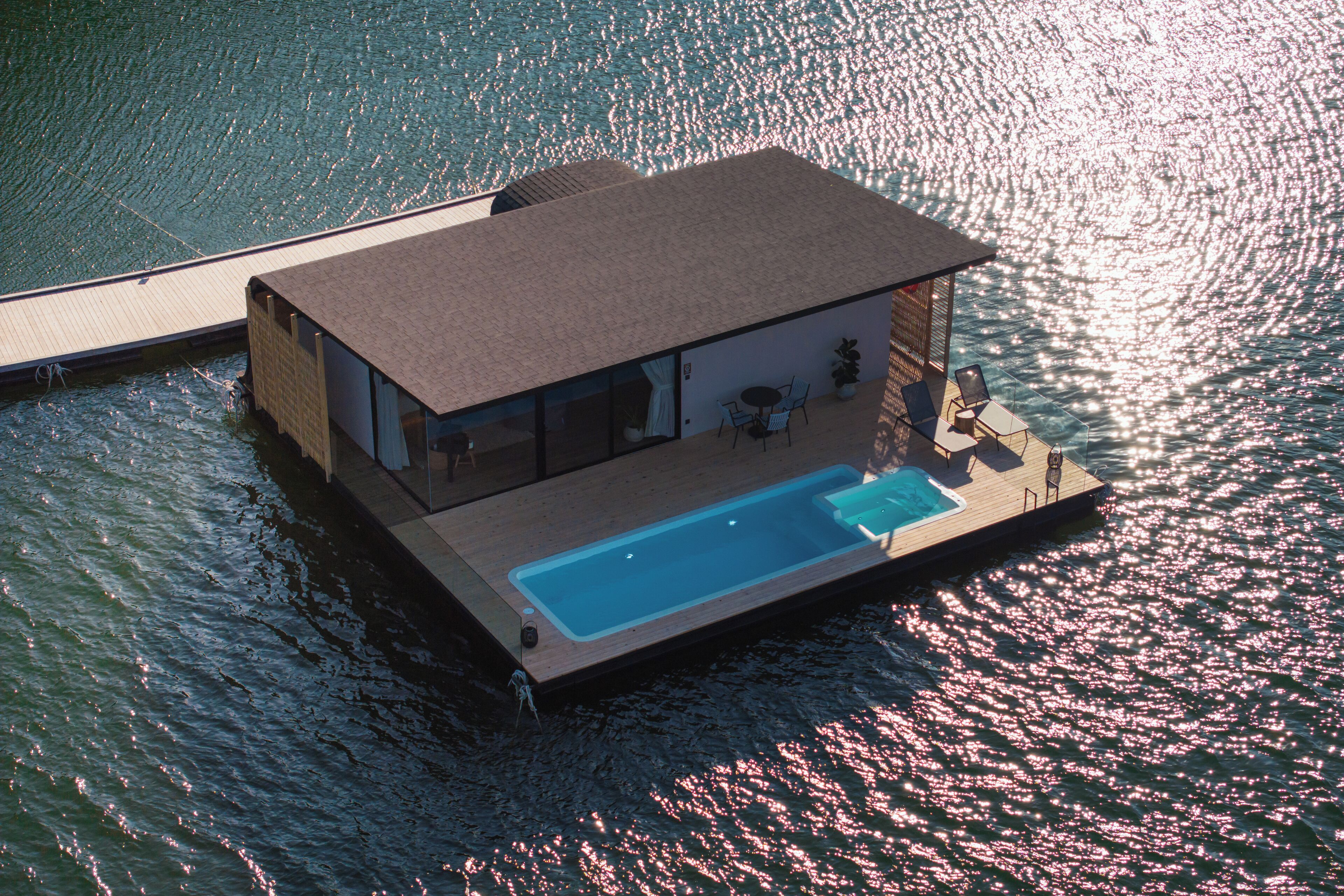 Ein schwimmendes Haus mit Pool, an einem Gewässer gelegen.