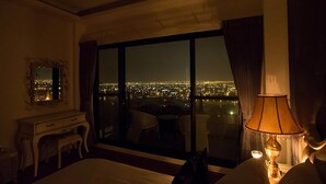 A hotel room with a large window offering a city view at night. - Moonstone Bed and Breakfast (Sanxing)