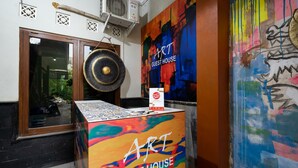 An interior with a colorful mural, a large gong, and a sign for 'ART GUEST HOUSE'. - Hotel O Art Guest House Syariah (Yogyakarta)