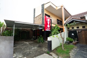 A two-story building with a covered outdoor area and a red banner advertising an art guesthouse. - Hotel O Art Guest House Syariah (Yogyakarta)