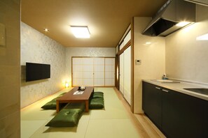 Relax in a minimalist space with a low table, bench, and flat-screen TV.