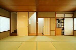 Um quarto japonês tradicional com piso de tatame, portas deslizantes e um armário embutido.