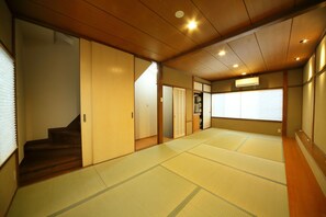 Experience the tranquility of a traditional Japanese-style room with tatami flooring, a wooden staircase, and sliding doors.