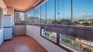 Un balcon avec vue sur le paysage urbain, un réfrigérateur et un évier.