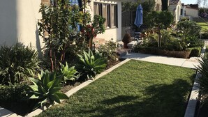 A well-maintained garden with a lawn, various plants, and a patio area with outdoor furniture. - Beautiful Private Home in Long Beach near Convention Center and Queen Mary (Long Beach)