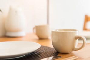 A table with a white mug, a white plate, and a woven placemat. - Seaside Room Namba (Osaka)