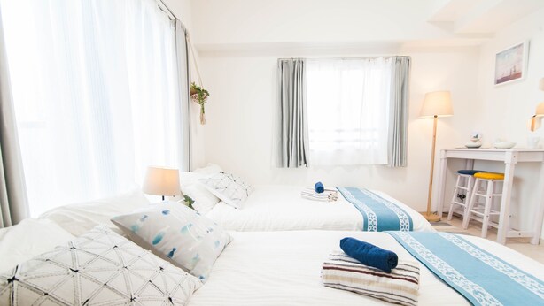 Une chambre d’hôtel avec deux lits, un bureau et une chaise.