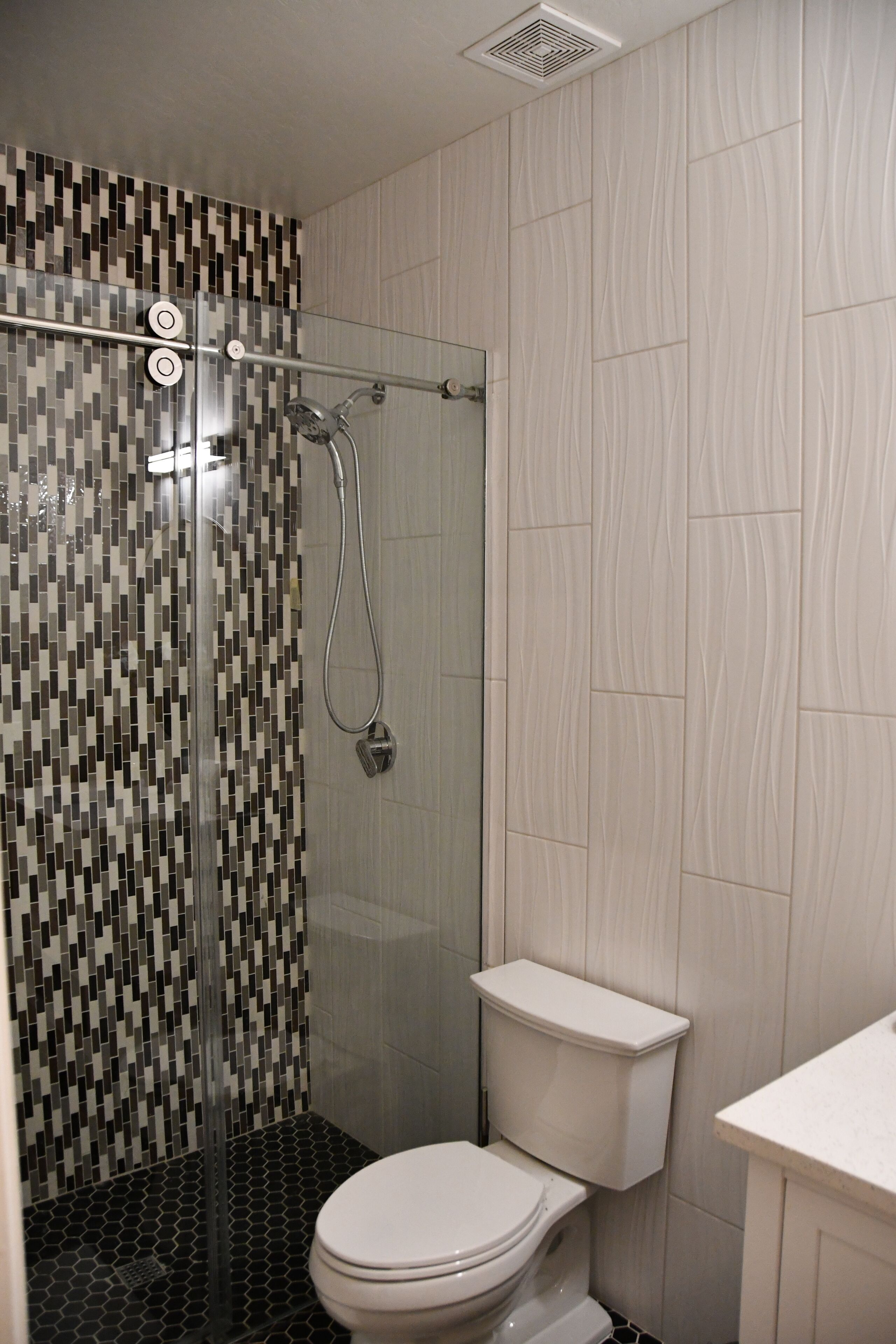 Ein Badezimmer mit Dusche, Toilette und Waschbecken.