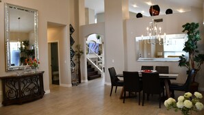 A spacious dining area with a chandelier, a large mirror, and a staircase leading to an upper level. - Near Scottsdale Area, Minutes From High end Shopping Malls and Restaurants (Phoenix)