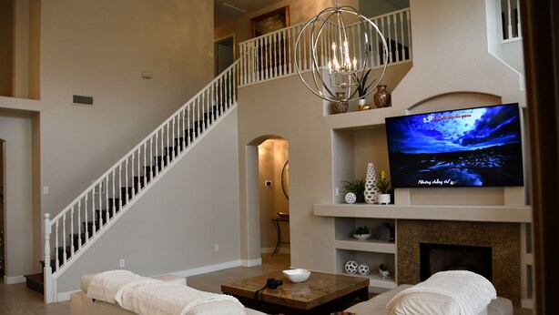 A living room with a large flat-screen TV, a fireplace, a staircase, and a cozy seating area. - Near Scottsdale Area, Minutes From High end Shopping Malls and Restaurants (Phoenix)