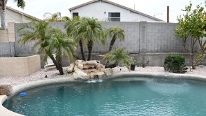 A swimming pool with palm trees and a small waterfall feature. - Near Scottsdale Area, Minutes From High end Shopping Malls and Restaurants (Phoenix)