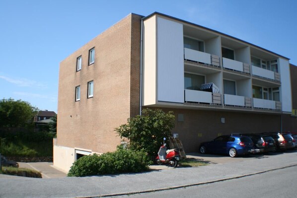 Ein mehrgeschossiges Gebäude mit Ziegelaußenwand und weißen Balkonen.