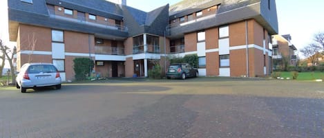 En byggnad med flera våningar, en fasad av tegel, ett platt tak och en innergård.