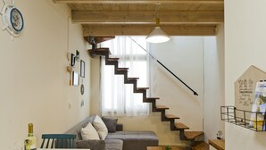 A modern living room with a staircase, a dining area, and a kitchen. - Stylish flat at Rothschild boulevard (Tel Aviv)