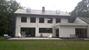 A modern two-story house with a large front porch, multiple windows, and a covered patio area. - B&B Golf Schilde (Schilde)