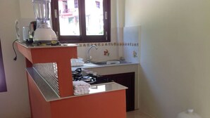 A small kitchen with a gas stove, a sink, and a window.