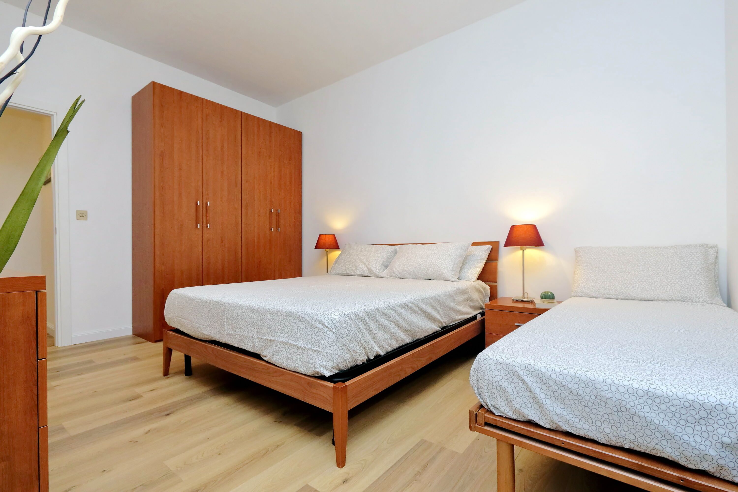 Una camera da letto con un letto di legno, un armadio e due lampade da comodino.