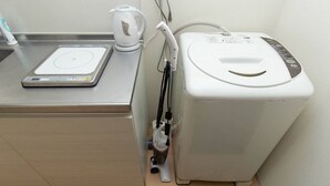 A kitchen with a digital scale, a kettle, and a coffee maker. - Guesthouse Daikokucho Ekimae (Osaka)