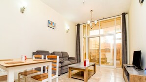 Un soggiorno moderno con zona pranzo, divano, tavolino e televisore.