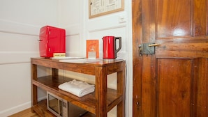 A wooden table with a red kettle, a coffee pot, and a menu on a wall-mounted board. - Midi Guestrooms (Martigny)