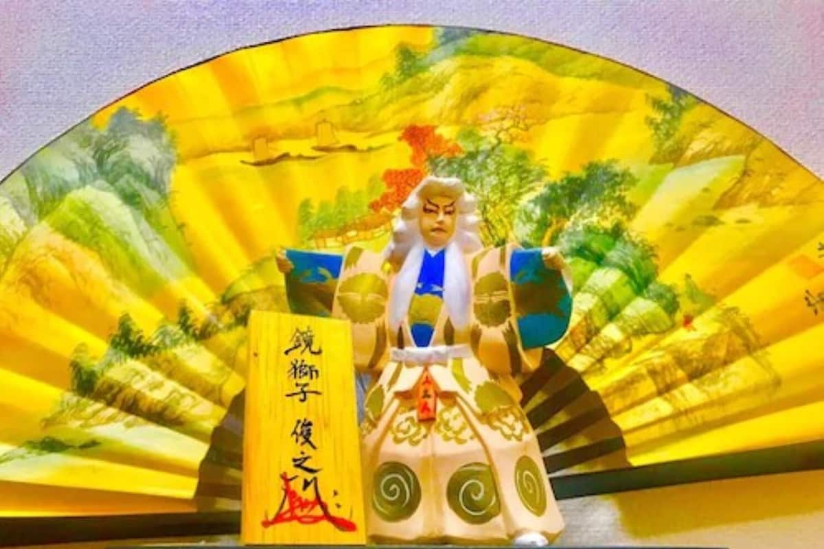 A traditional Chinese figure with a fan and a scroll.